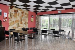 comedor con mesa, sillas y pared de piedra en Penzion-Bar Sandra, en Bělkovice