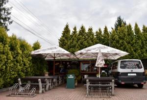 una furgoneta de comida estacionada junto a mesas y sombrillas en Penzion-Bar Sandra, en Bělkovice