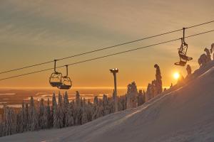 a ski lift going up a snow covered slope at sunset at Break Sokos Hotel Tahko in Tahkovuori +87 photos