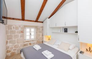 1 dormitorio con cama y pared de piedra en Ragusa City Walls Apartments en Dubrovnik