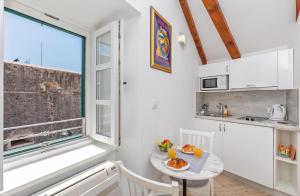 uma pequena cozinha com uma mesa e uma janela em Ragusa City Walls Apartments em Dubrovnik