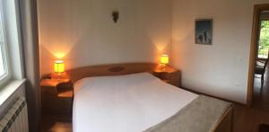 a bedroom with a white bed and two lamps at Apartment Luiza Funtana in Funtana