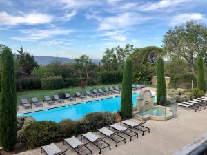 a pool with chaise lounge chairs at Cigale de Gordes in Gordes
