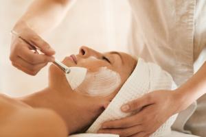 a woman getting her face groomed by a beautician at Capovaticano Resort Thalasso Spa in Capo Vaticano