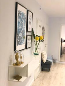 a living room with a shelf with flowers and a chair at Ferienwohnung Domizil am Delft Emden in Emden