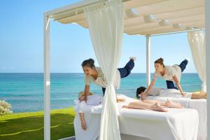a group of women jumping on beds on the beach at Capovaticano Resort Thalasso Spa in Capo Vaticano