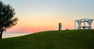 a couple standing on top of a hill at sunset at Capovaticano Resort Thalasso Spa in Capo Vaticano