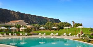 a pool with chairs and umbrellas in a resort at Capovaticano Resort Thalasso Spa in Capo Vaticano