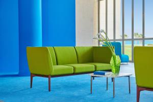 a green couch in a room with a table at Capovaticano Resort Thalasso Spa in Capo Vaticano