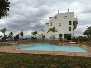 a building with a swimming pool in front of a building at Fairway View Penthouse in Murcia
