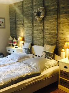 a bedroom with two beds and a wooden wall at Gästehaus Sellemols Ferienwohnung Küfer in Heuchelheim-Klingen