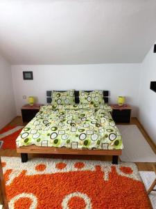 a bedroom with a bed with an orange rug at Casa Ani in Borşa