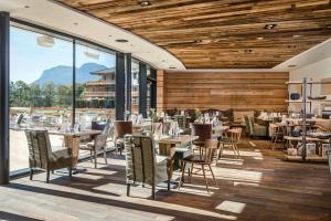 een restaurant met houten plafonds en tafels en stoelen bij Kaiserlodge in Scheffau am Wilden Kaiser