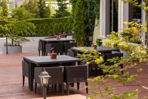 un grupo de mesas y sillas en un patio en Hotel Jan Sander en Aleksandrów Łódzki