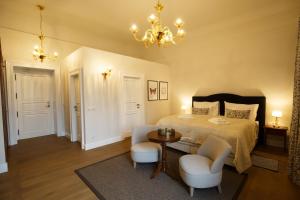 1 dormitorio con 1 cama, mesa y sillas en Hotel Château Gbeľany en Žilina