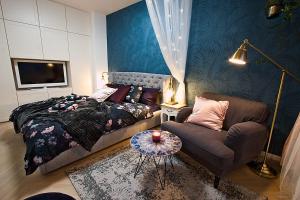 a bedroom with a bed and a couch and a tv at Romantic designer apartment Prague in Prague