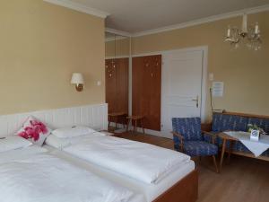 a bedroom with two beds and a table and chairs at Hotel - Garni Stabauer in Mondsee