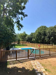 a wooden fence with a swimming pool in a yard at Can Gich Espacio Rural in Celrá