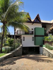 a house with a palm tree and a driveway at Apartamento Solar do Forte - Praia do Forte in Praia do Forte +33 photos