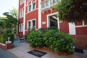 un edificio rosso e bianco con un cartello davanti di Hotel Villa Pannonia a Lido di Venezia
