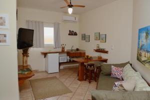 a living room with a couch and a kitchen at Pousada Villa Maritima in Juquei