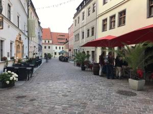 a cobblestone street in a city with people standing around at Pirna-Apartment in Pirna +14 photos