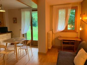eine Küche und ein Wohnzimmer mit einem Tisch und einem Fenster in der Unterkunft Chamonix Studio Jardin in Chamonix-Mont-Blanc