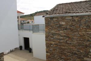 a building with a stone wall next to a building at Casal da Porta - Quinta da Porta in Mirandela