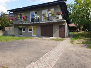 a house with a balcony with flowers on it at Pokoje Gościnne Grzybowo in Grzybowo +2 photos