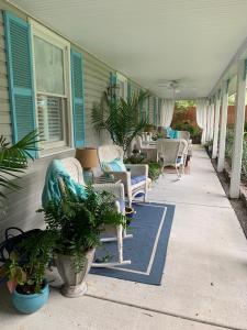 eine Veranda mit Stühlen und Pflanzen an einem Haus in der Unterkunft Caroline's Bed and Breakfast in Summerville