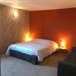 a bedroom with a bed with red walls and two lamps at La bacchante in Saint-Hippolyte