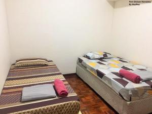 2 Einzelbetten in einem Zimmer mit roten Kissen in der Unterkunft 6-8pax Cozy Homestay @ Teluk Kemang Port Dickson in Port Dickson