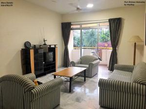 ein Wohnzimmer mit 2 Sofas und einem Tisch in der Unterkunft 6-8pax Cozy Homestay @ Teluk Kemang Port Dickson in Port Dickson