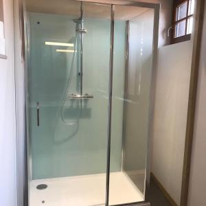 La salle de bains est pourvue d'une douche avec une porte en verre. dans l'établissement La bacchante, à Saint-Hippolyte