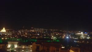- une vue sur la ville la nuit avec des lumières dans l'établissement Apartment Panorama, à Tbilissi