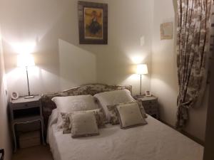 een slaapkamer met een bed met kussens en 2 lampen bij JOLI MAZET ST TROPEZ in Gassin +26 foto's