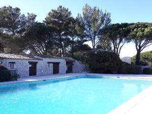een zwembad voor een stenen huis bij JOLI MAZET ST TROPEZ in Gassin