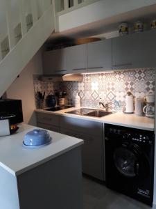 een keuken met een spoelbak en een wasmachine bij JOLI MAZET ST TROPEZ in Gassin