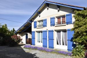 uma casa azul e branca com muitas janelas em Maison dans le vignoble de Bordeaux-Blaye-Bourg-CNPE em Saint-Trojan