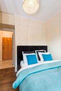 sypialnia z dużym łóżkiem z niebiesko-białymi poduszkami w obiekcie Super-Apartamenty Targi Poznańskie w Poznaniu