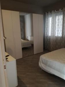 1 dormitorio con cama y espejo grande en Affittacamere New Lifestyle, en Alberoro