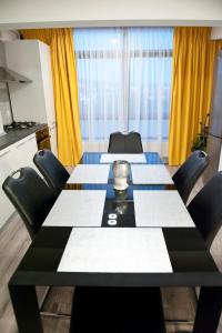 una sala de reuniones con una mesa larga y sillas en CosmopolitApart, en Sibiu