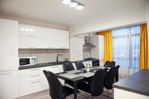 Una cocina y un comedor con mesa y sillas. en CosmopolitApart, en Sibiu