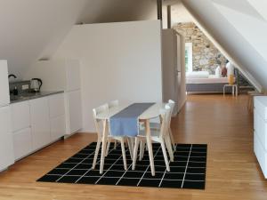 a kitchen with a table and chairs on a rug at Dom Gościnny pod Zamkiem Wleń in Wleń