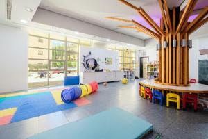 Habitación con mesa, sillas y zona de juegos. en Hotel Envia Almería Spa & Golf, en Aguadulce