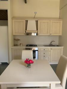 a kitchen with a white table with a vase of flowers on it at Villa Gruccione in Fossombrone