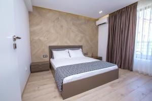 a bedroom with a bed with a wooden wall at South Place Apartments in Sandanski
