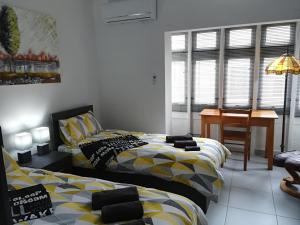 a bedroom with two beds and a desk in it at Luxury Apartment close to seafront in Sliema