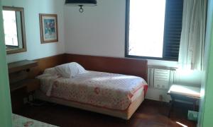 a small bedroom with a bed and two windows at Residencial flat Golden beach.. in Guarujá