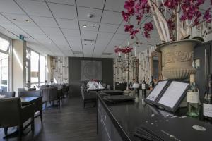 ein Restaurant mit einer Bar mit einer Blumenvase in der Unterkunft Fletcher Hotel Restaurant Zeeduin in Wijk aan Zee
